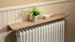 Hoe een plank boven de radiator de verwarming verbetert en uw energierekening verlaagt